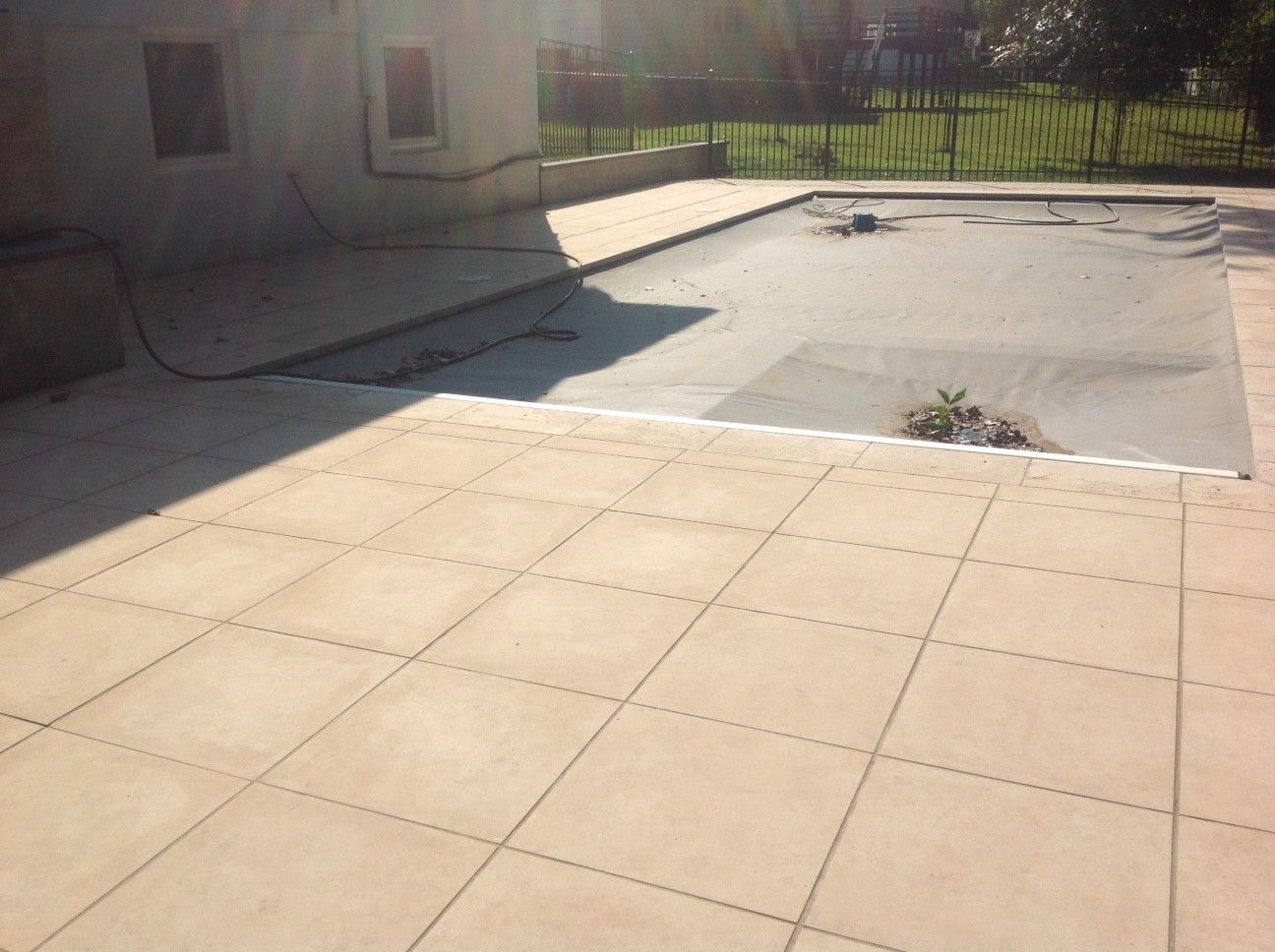 A patio with a swimming pool in the background.
