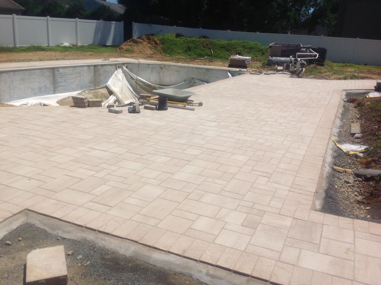 A patio is being built around a swimming pool