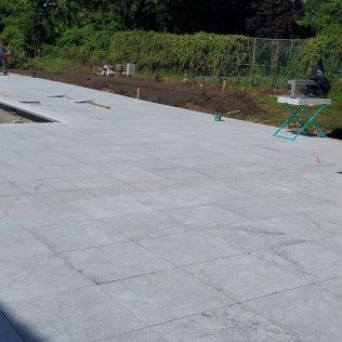 A large concrete patio is being built in a backyard.