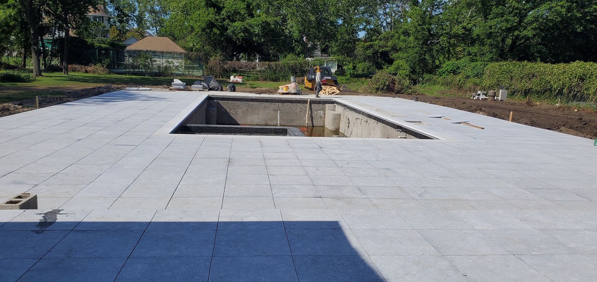 A large swimming pool is being built in a backyard.