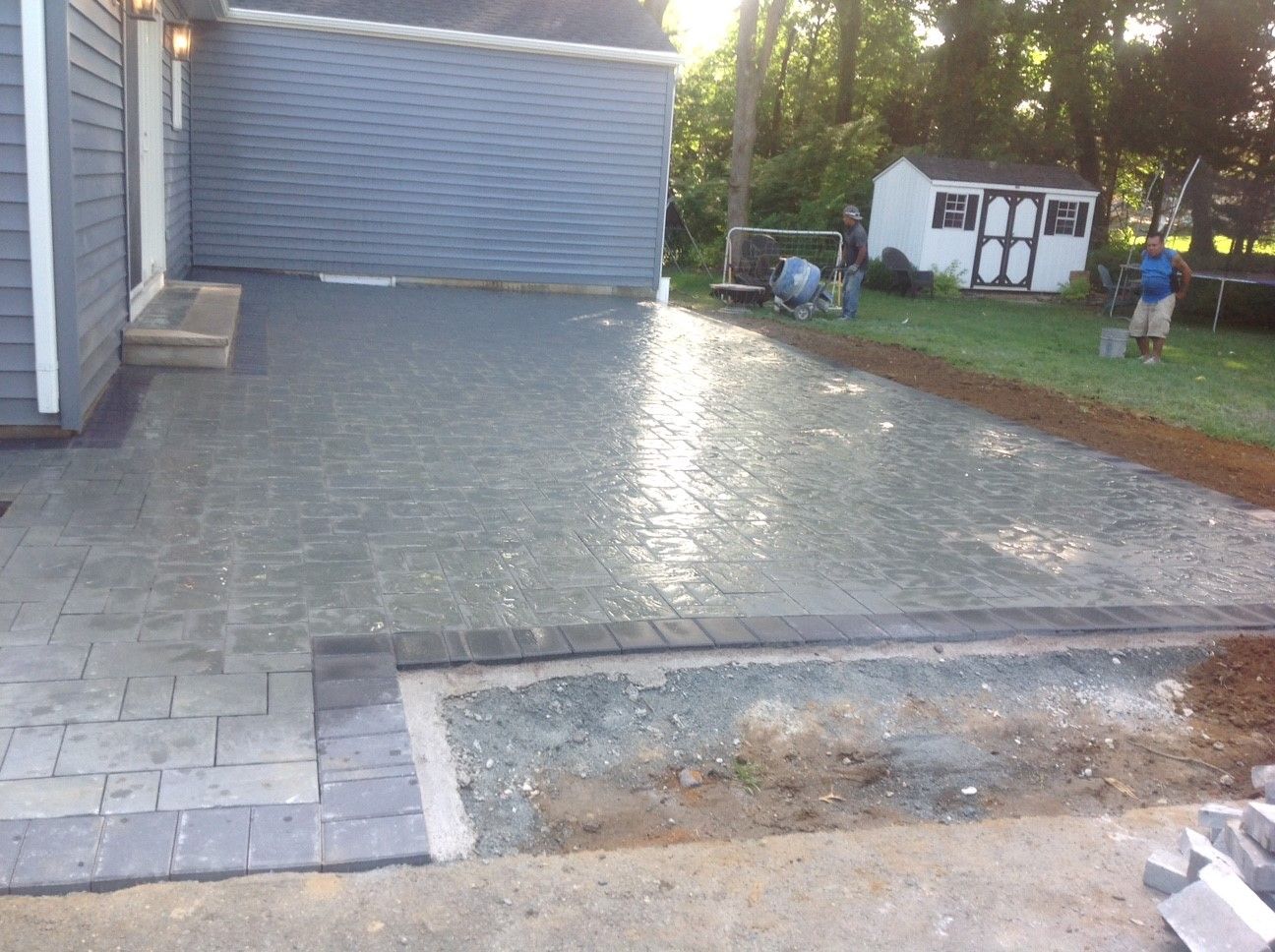 A brick driveway is being built in front of a house