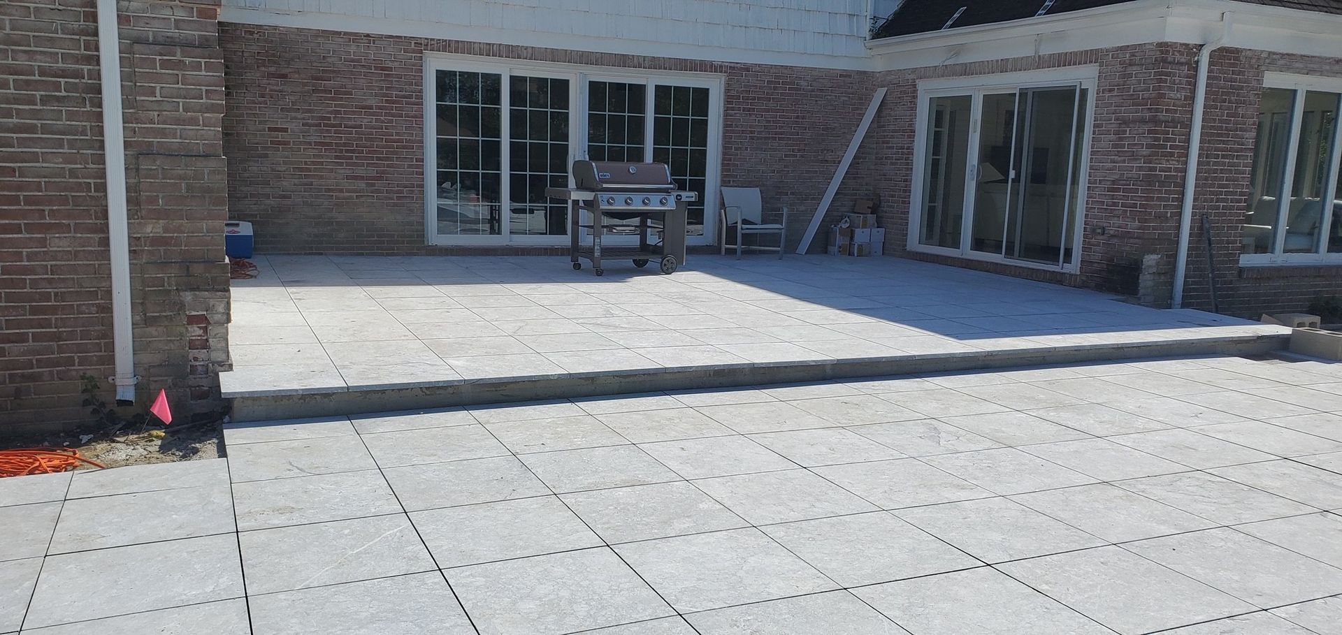 A patio with a table and chairs in front of a brick building.