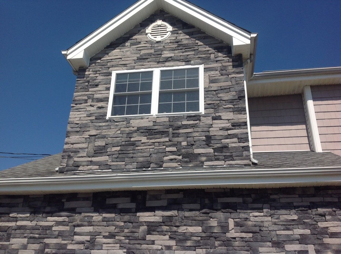 A house with a stone facade and two windows