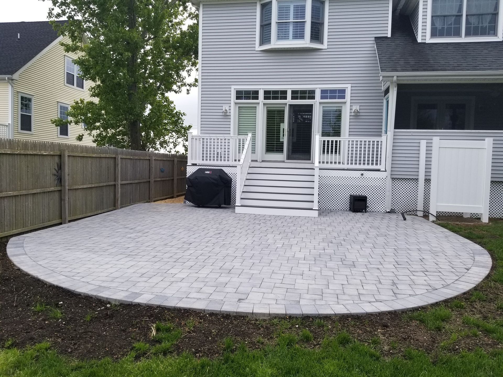 A large white house with a patio in front of it.