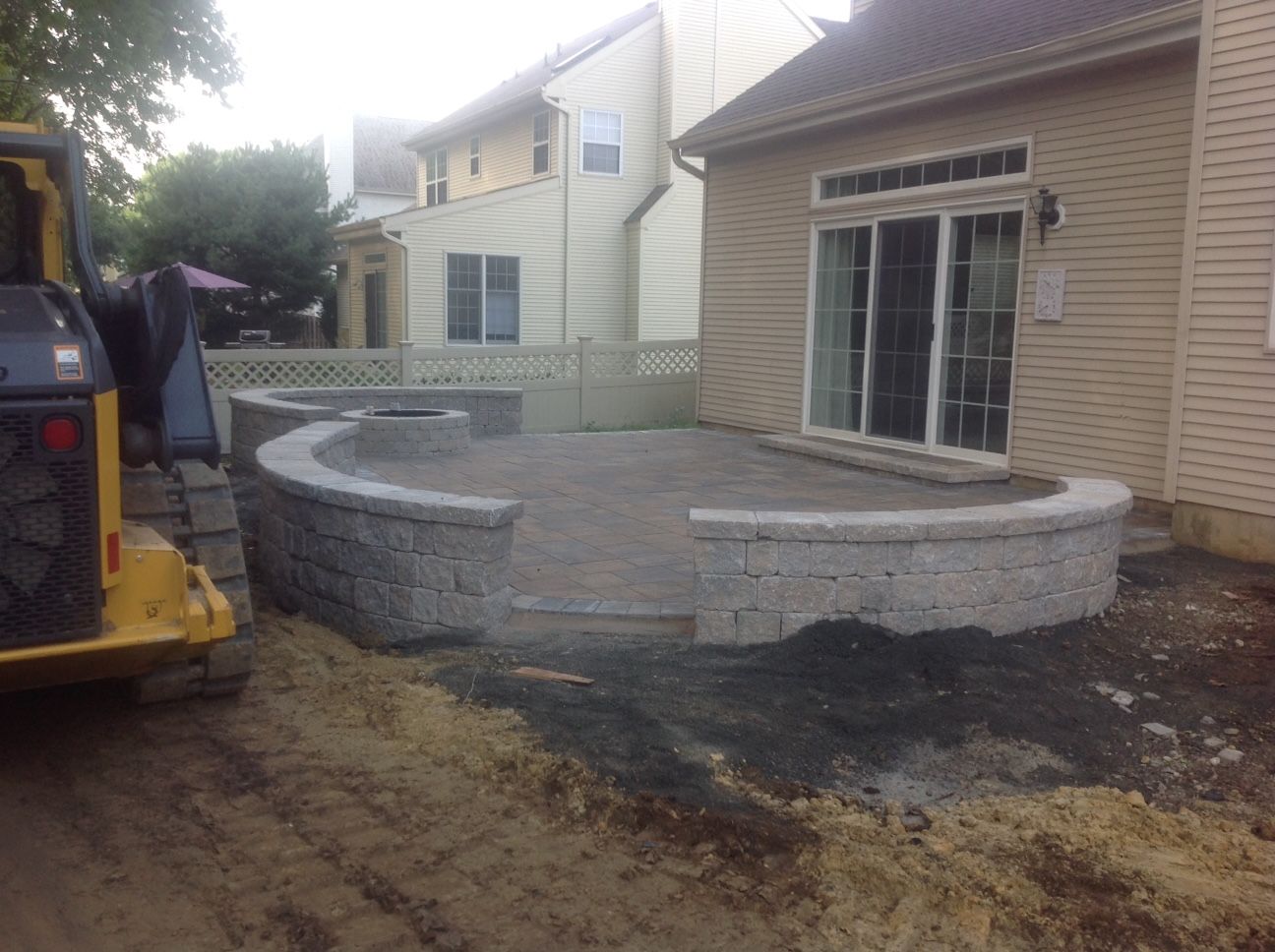 A house with a patio being built in front of it.