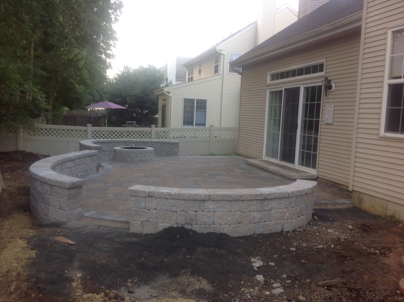 There is a fire pit in the backyard of a house.