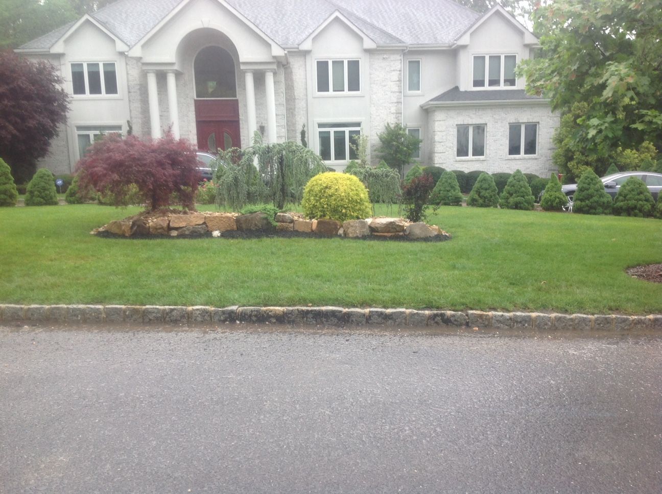 A large white house with a lush green lawn in front of it