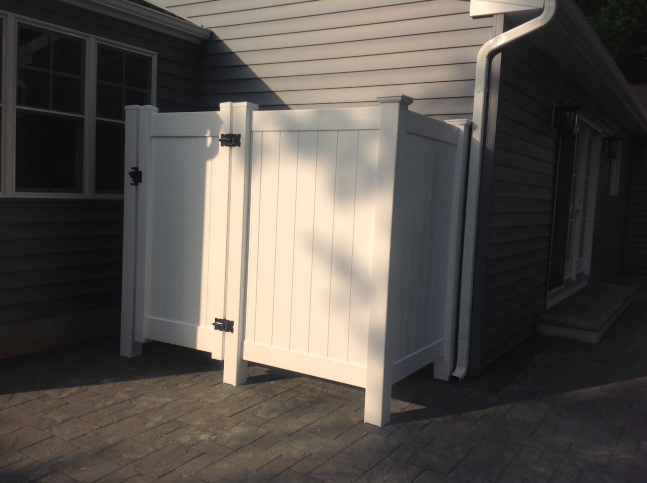A white fence is in front of a house