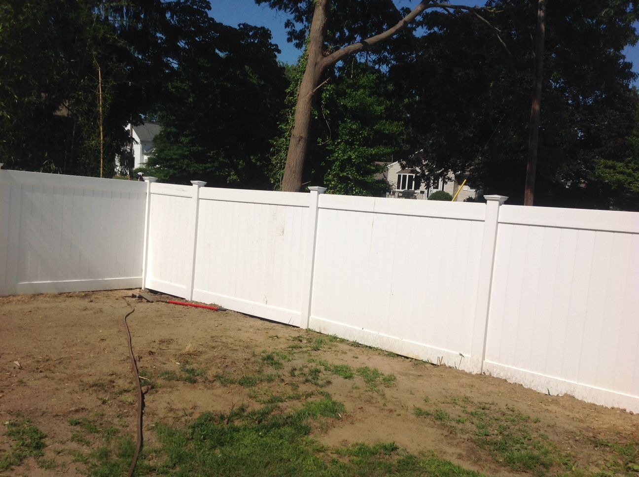 A white fence surrounds a lush green yard.
