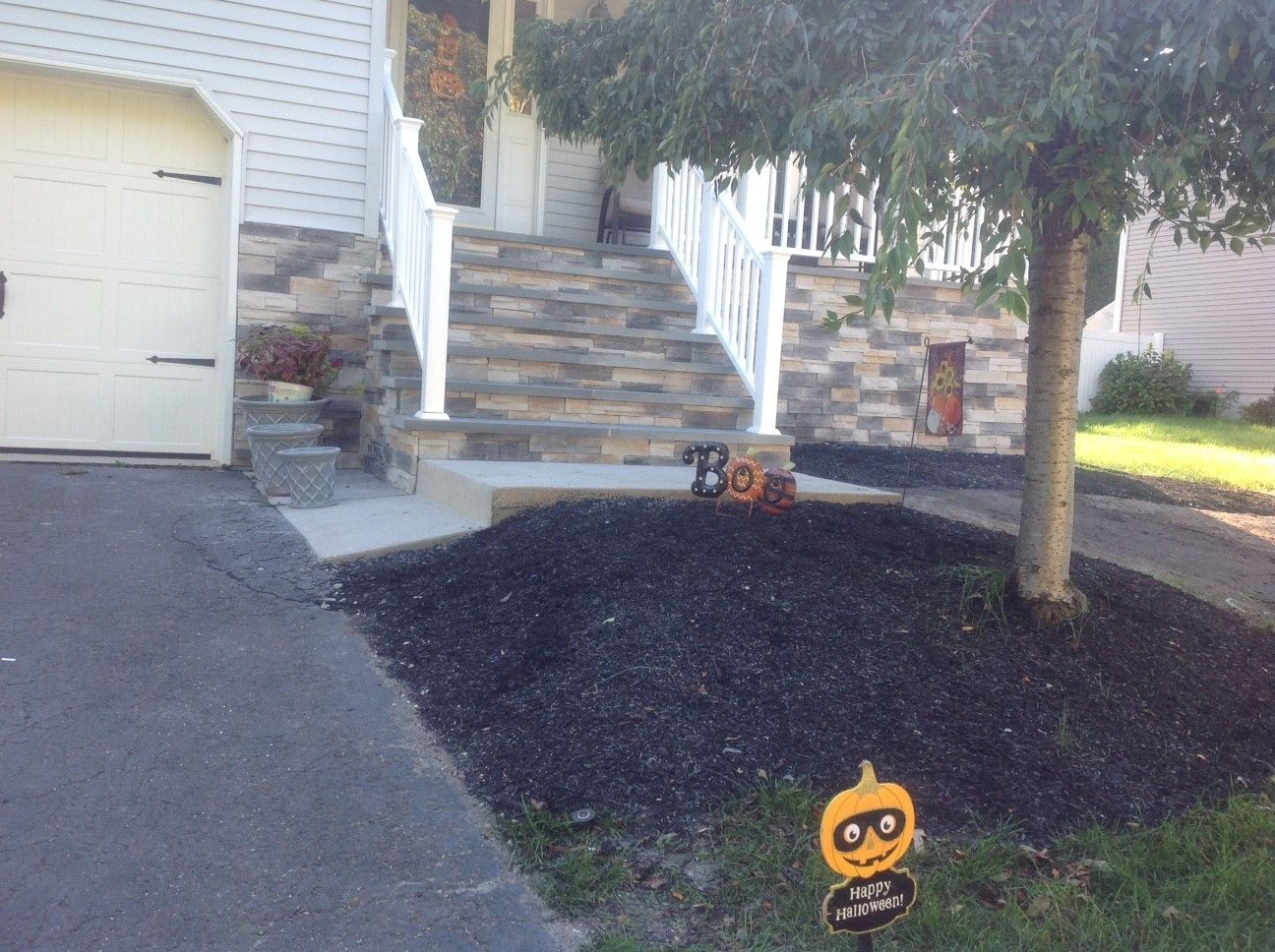 A sign that says boo is in front of a house.