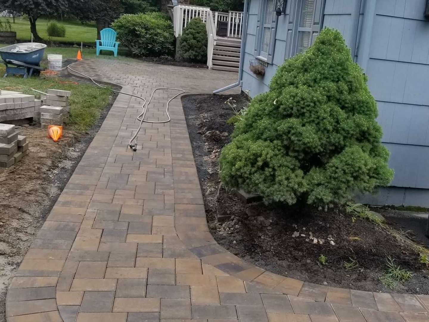 A brick walkway is being built in front of a house.