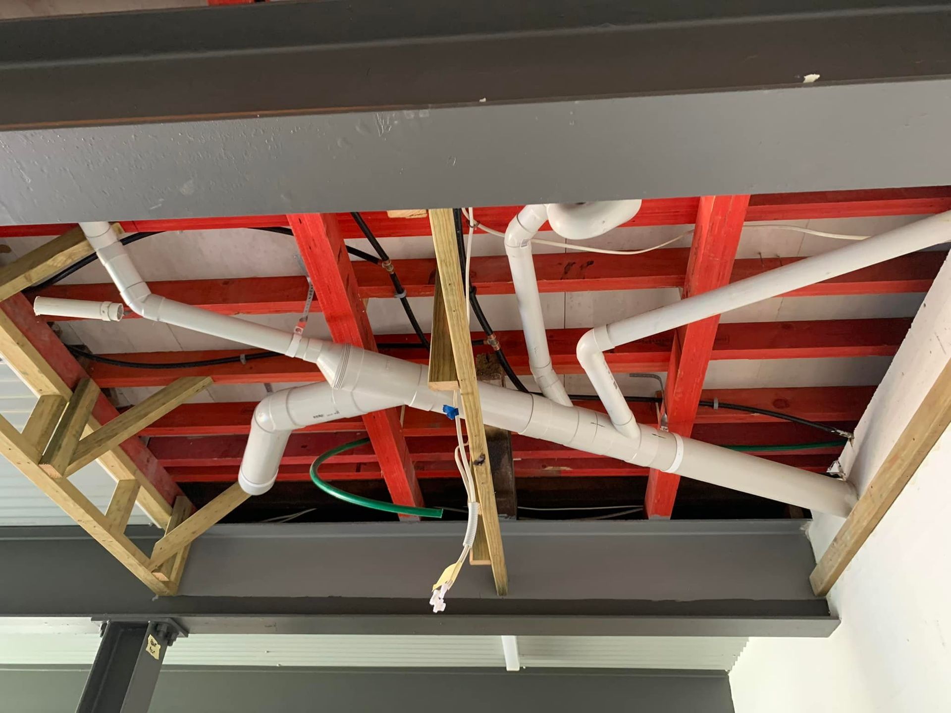 Red-Framed Wooden Ceiling with White Pipes and Wires — 2 Foote Plumbing & Gas in Darwin, NT