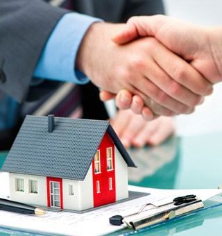 Shaking Hands over a contract and toy house