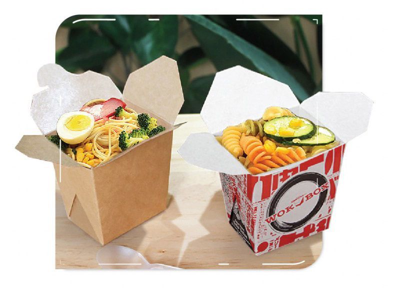 Two takeout boxes filled with pasta; one plain, one printed, on wooden surface.