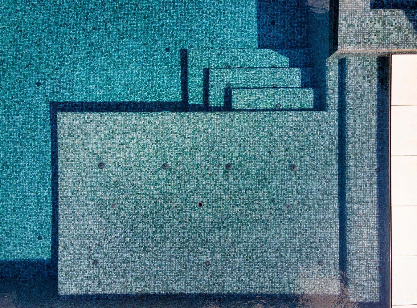 an aerial view of a swimming pool with blue tiles .