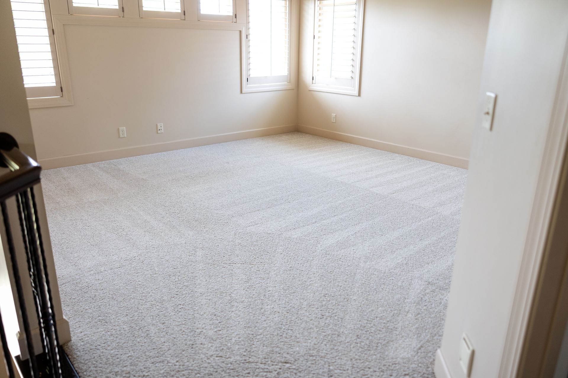 Clean carpet with carpet lines in a beige room.