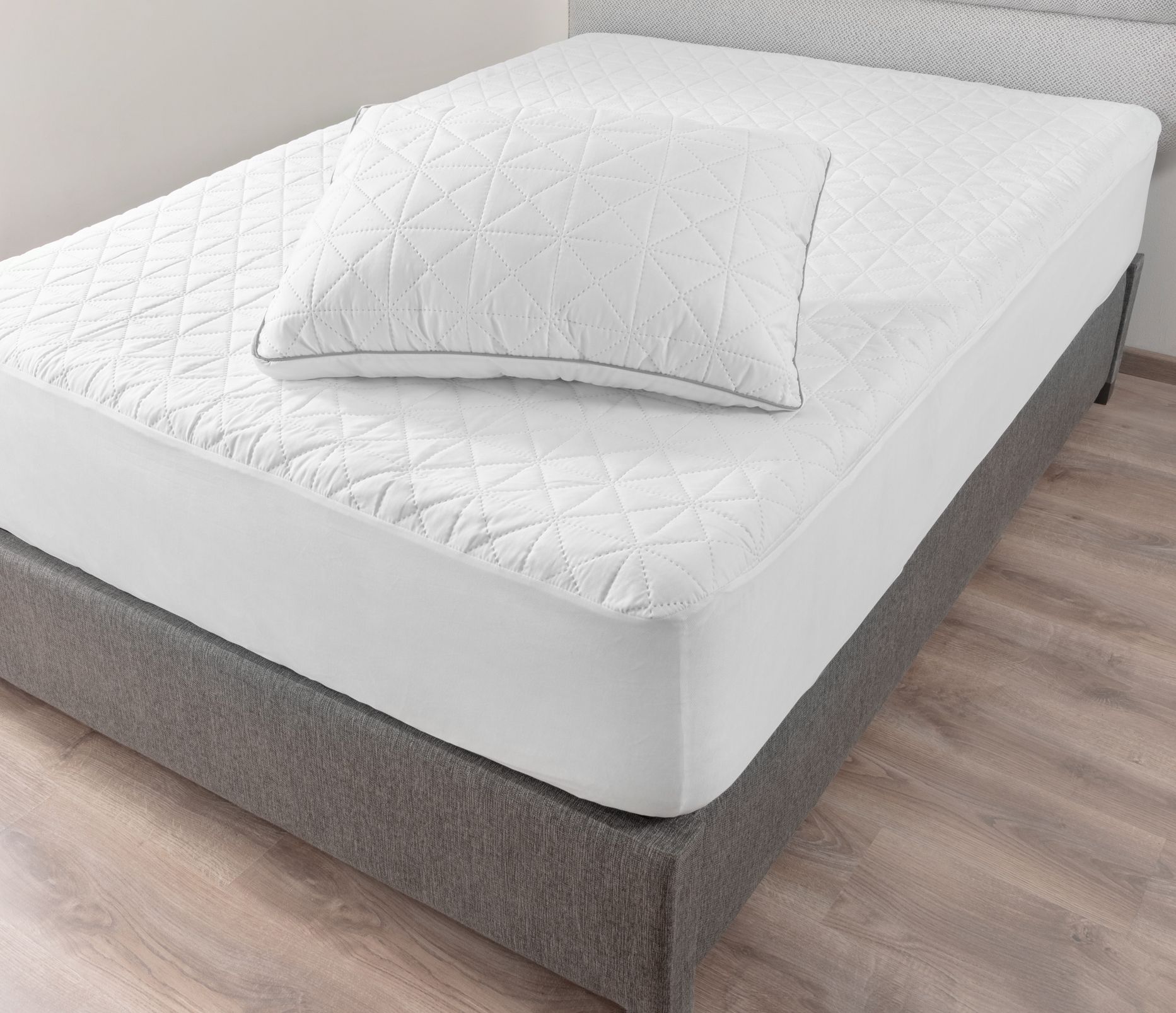 A man is cleaning a mattress with a vacuum cleaner.