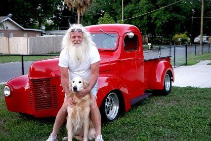 Old Man Sitting in Red Car with His Dog — Concrete Contractor in Tampa, FL