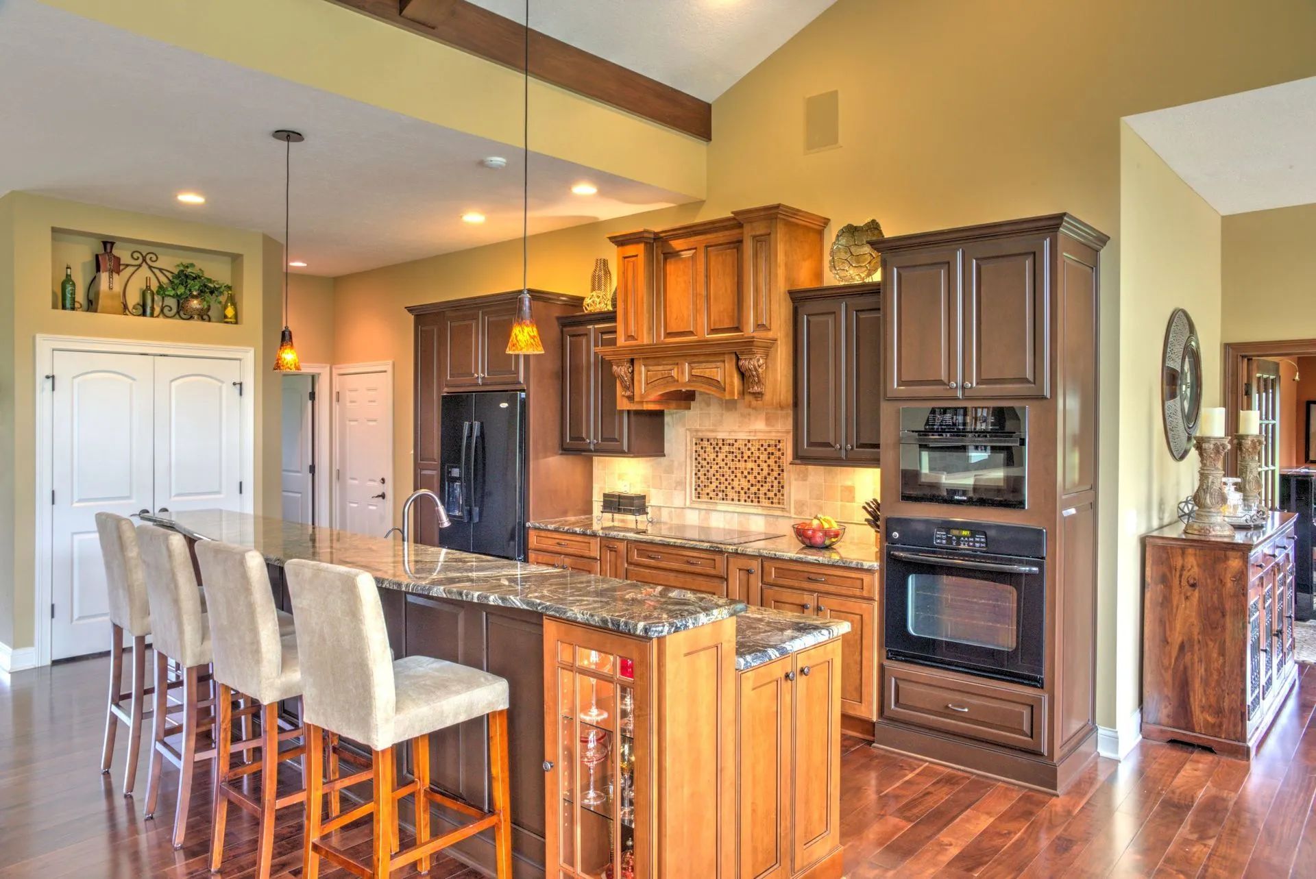 Kitchen with wood cabinets, island with stools, and built-in oven.
