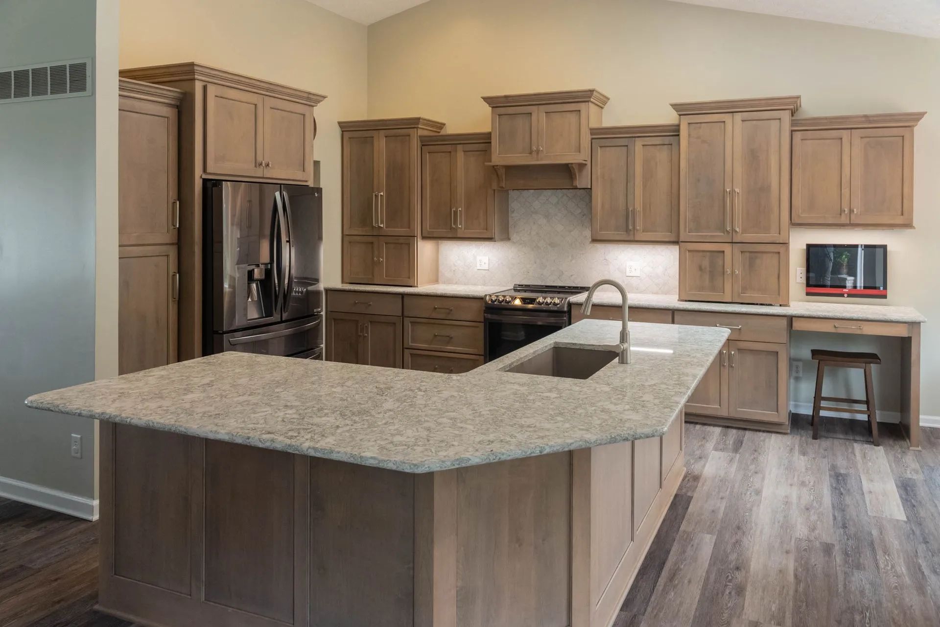 Kitchen with light brown cabinets, granite countertops, and stainless steel appliances.