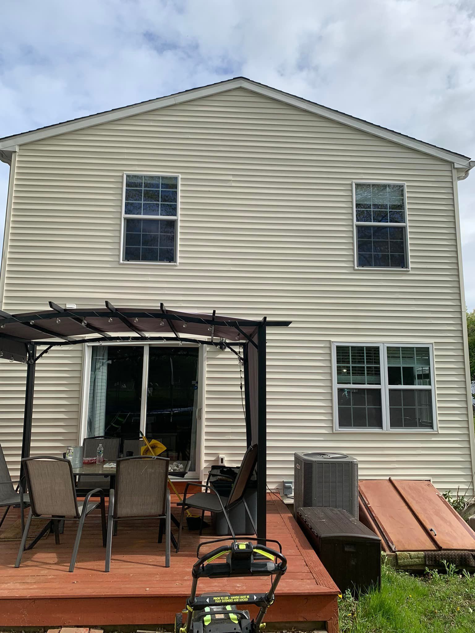 The back of a house with a wooden deck and a pergola.
