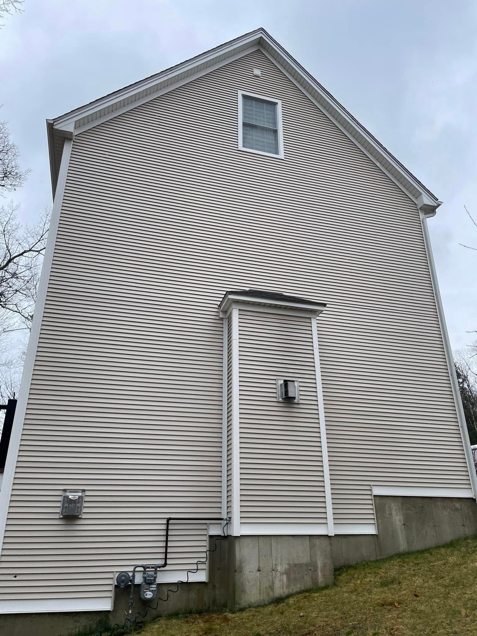 The back of a house with a striped siding and a door.