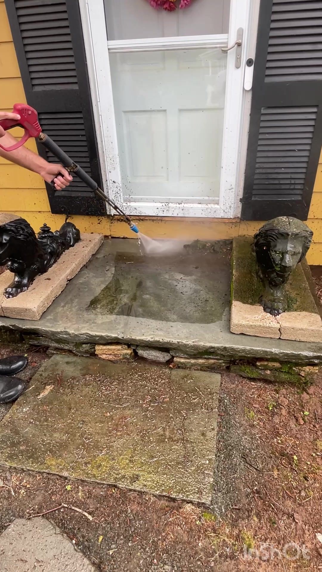 A person is cleaning a porch with a high pressure washer.