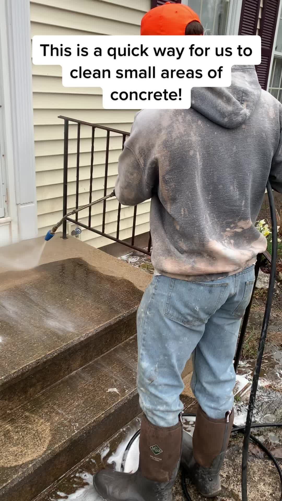 A man is using a pressure washer to clean small areas of concrete.