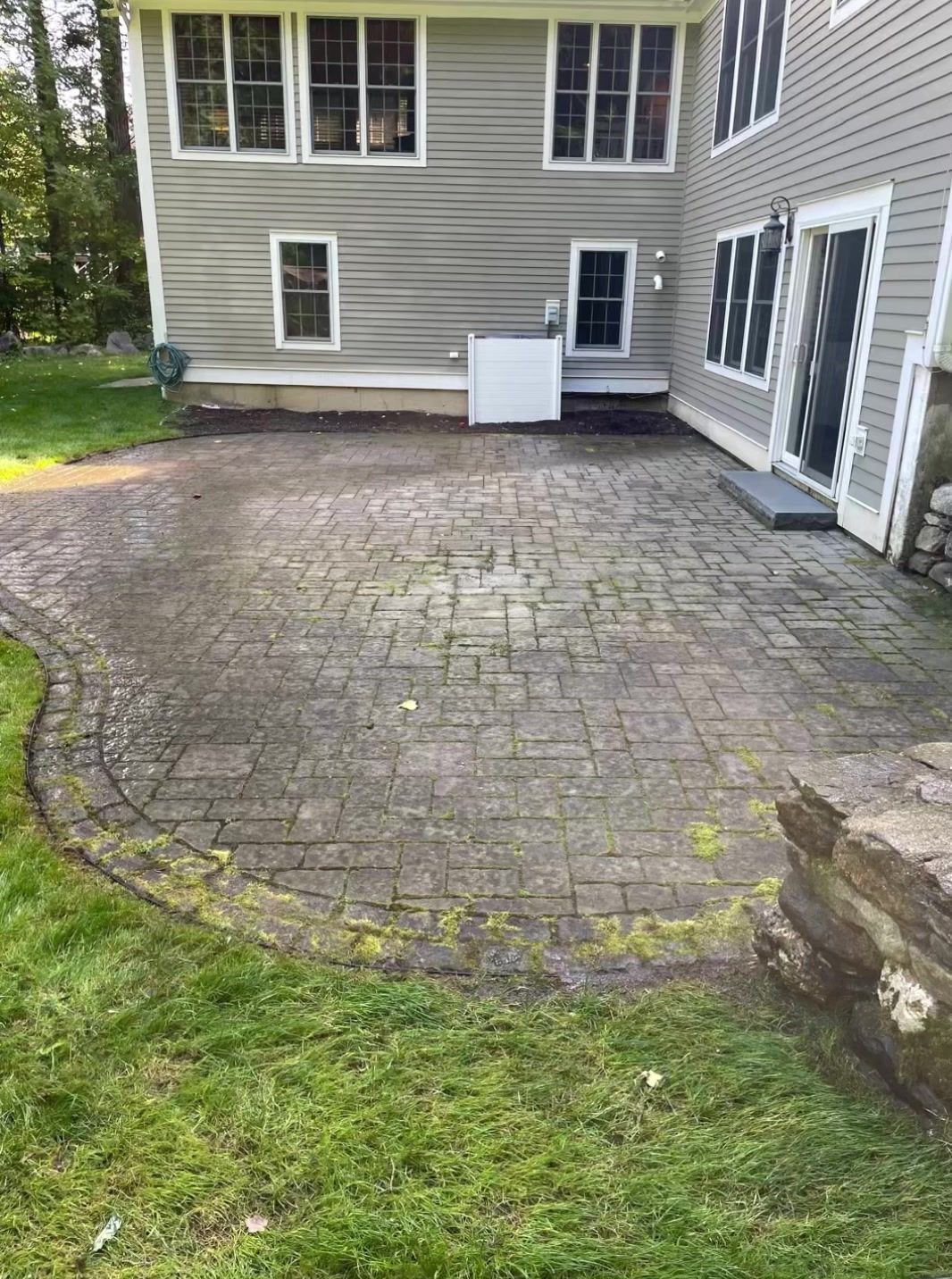 A patio in front of a house with a lot of grass.