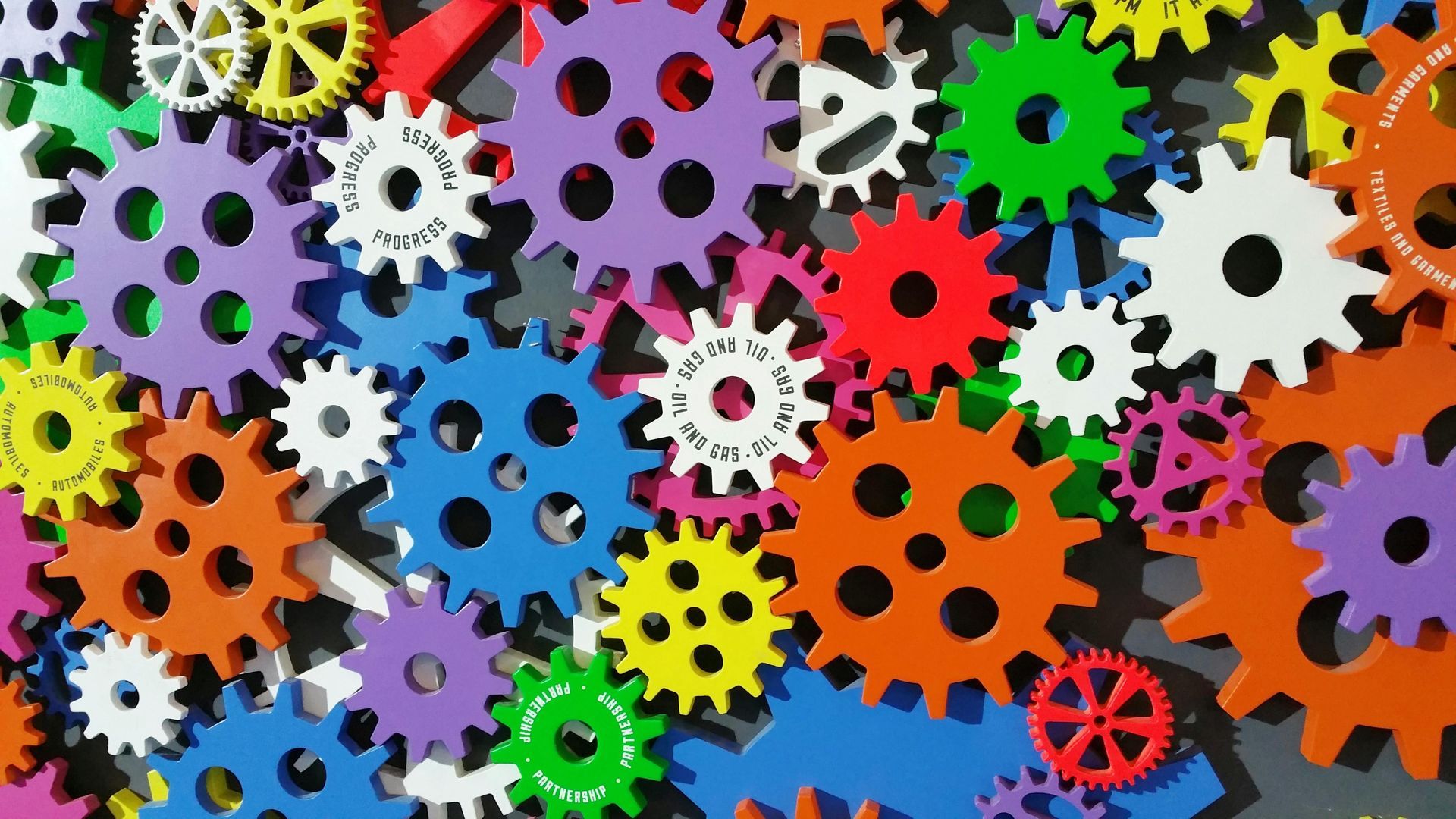 A bunch of colorful gears are lined up on a table.