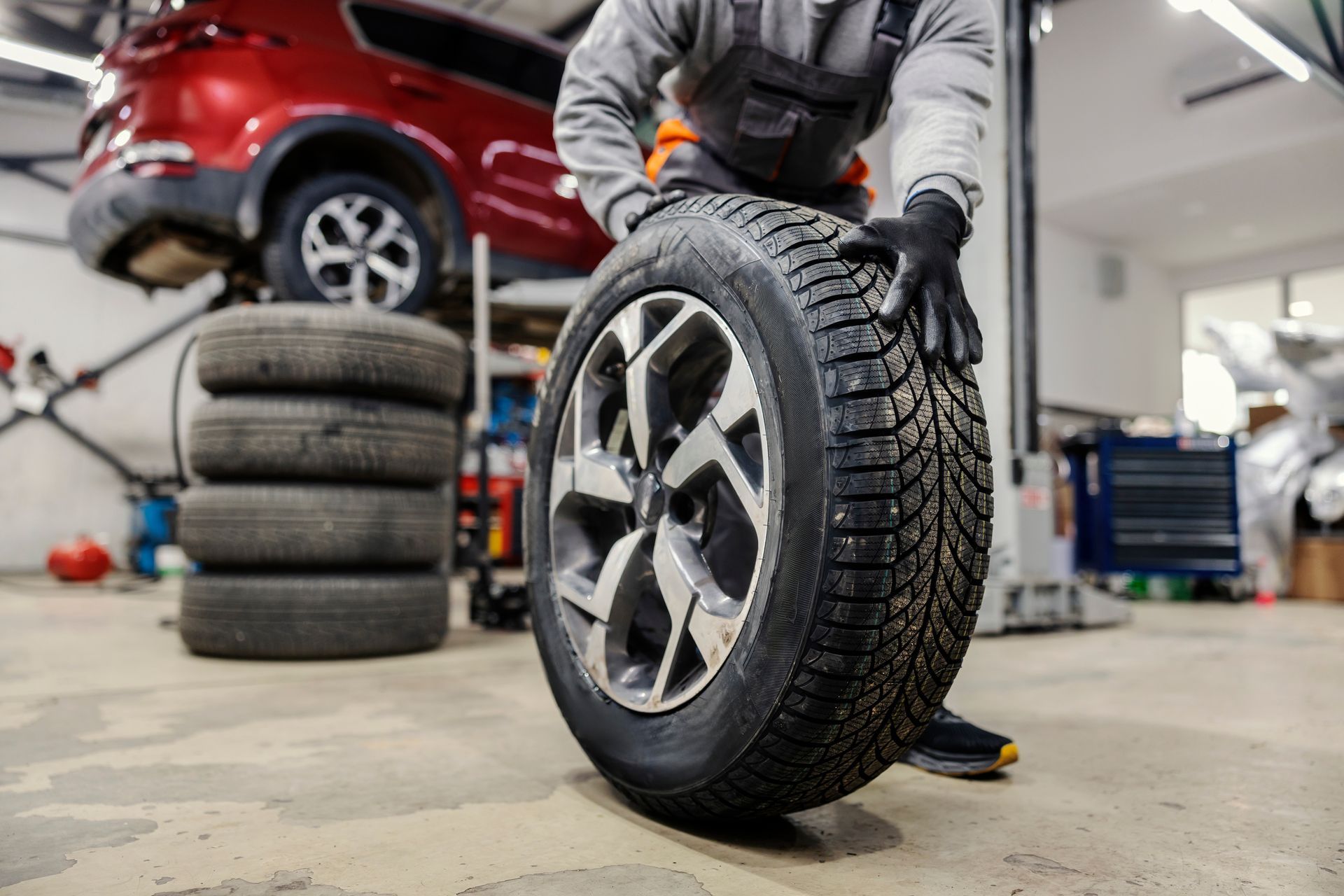 A man is changing a tire in a garage.