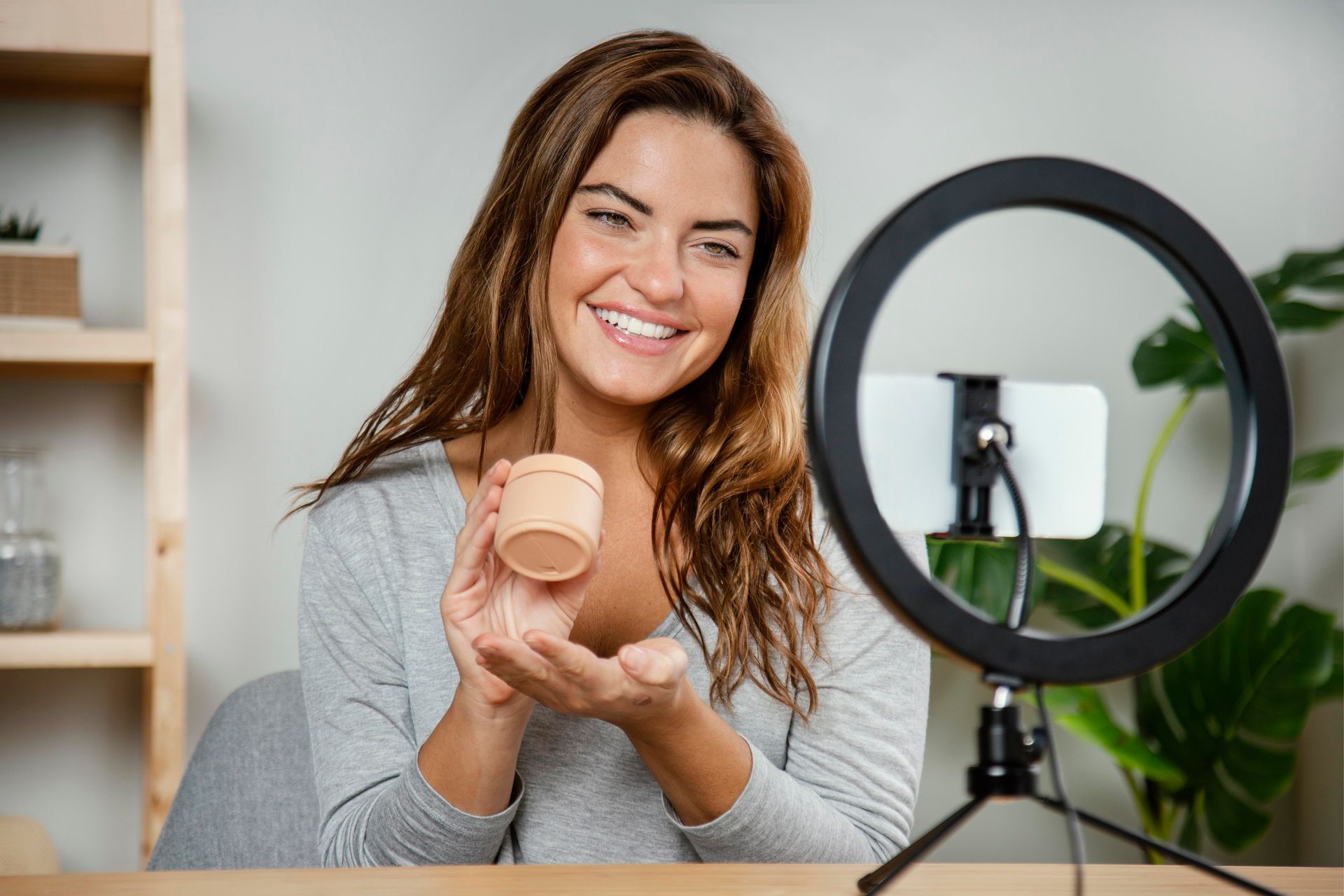 Influenciadora de beleza apresentando produto cosmético em gravação para redes sociais – tendências.