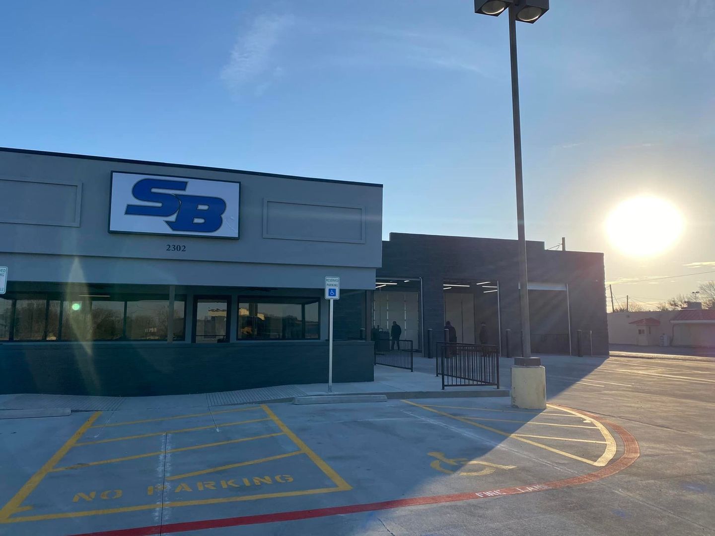 A sb car wash with a parking lot in front of it.