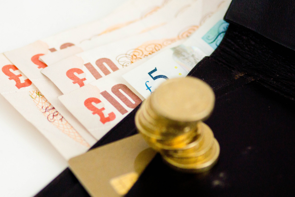 A person counting money, representing the UK spouse visa financial requirements