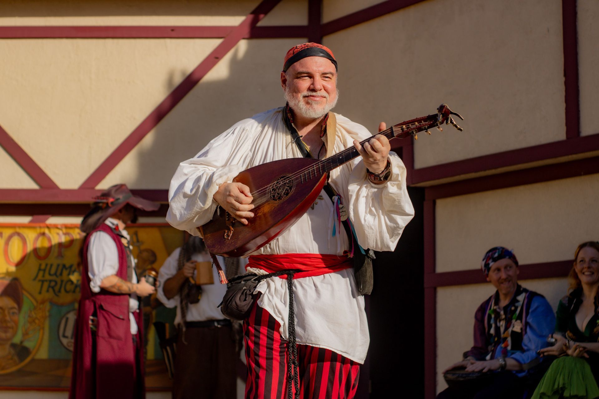 A man in a pirate costume is playing a guitar.