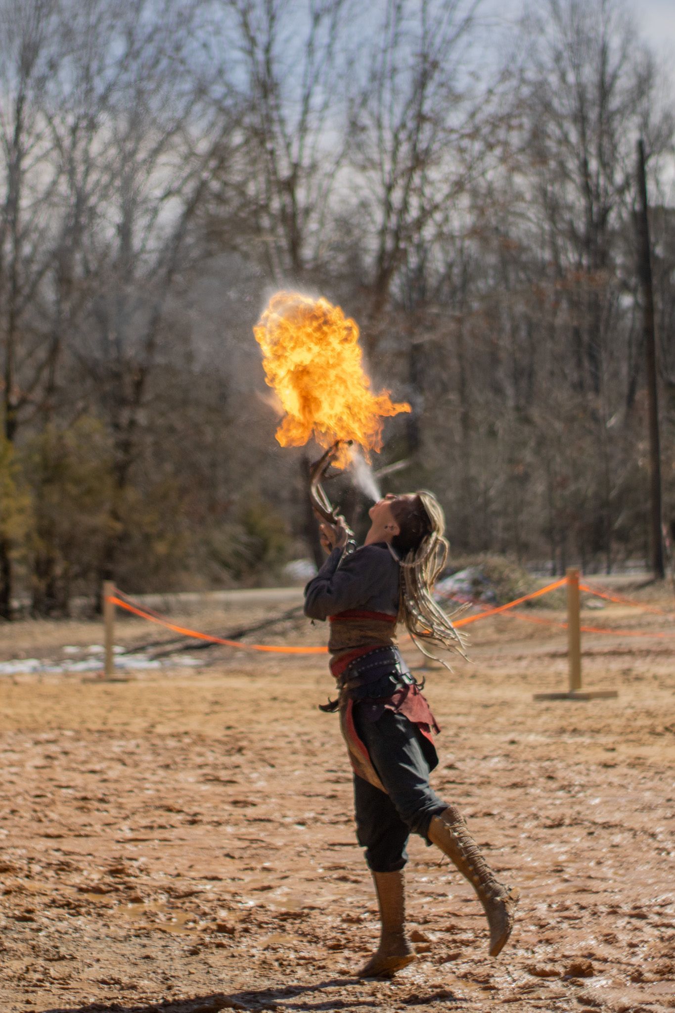 A woman is holding a torch with flames coming out of it.