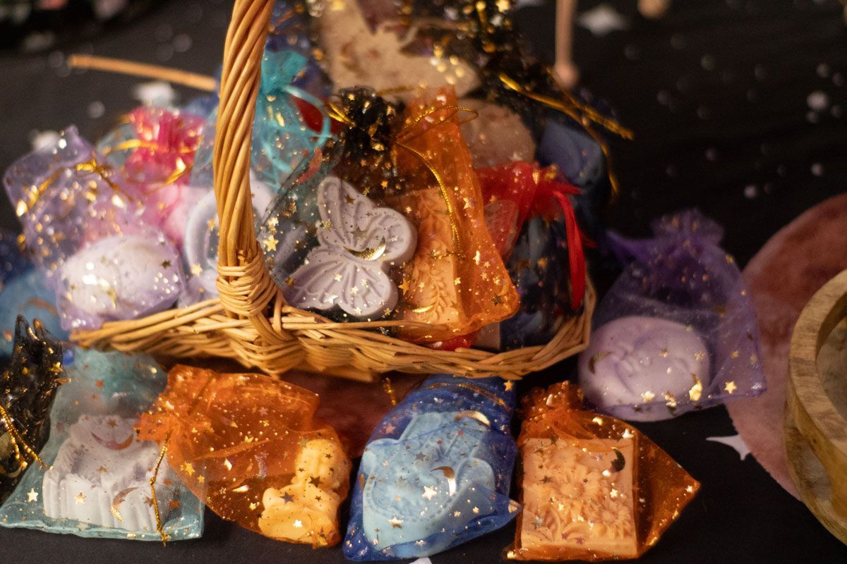 A basket filled with a variety of soaps in bags on a table.