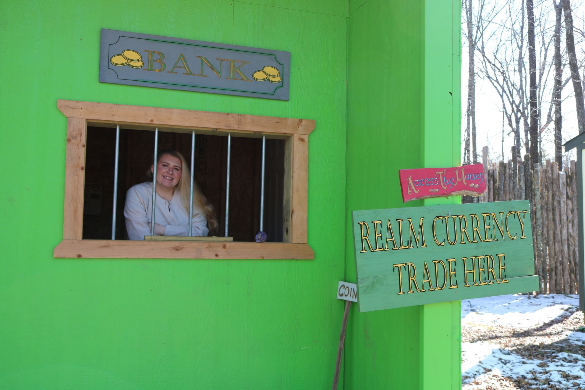 A woman is behind bars in a green bank