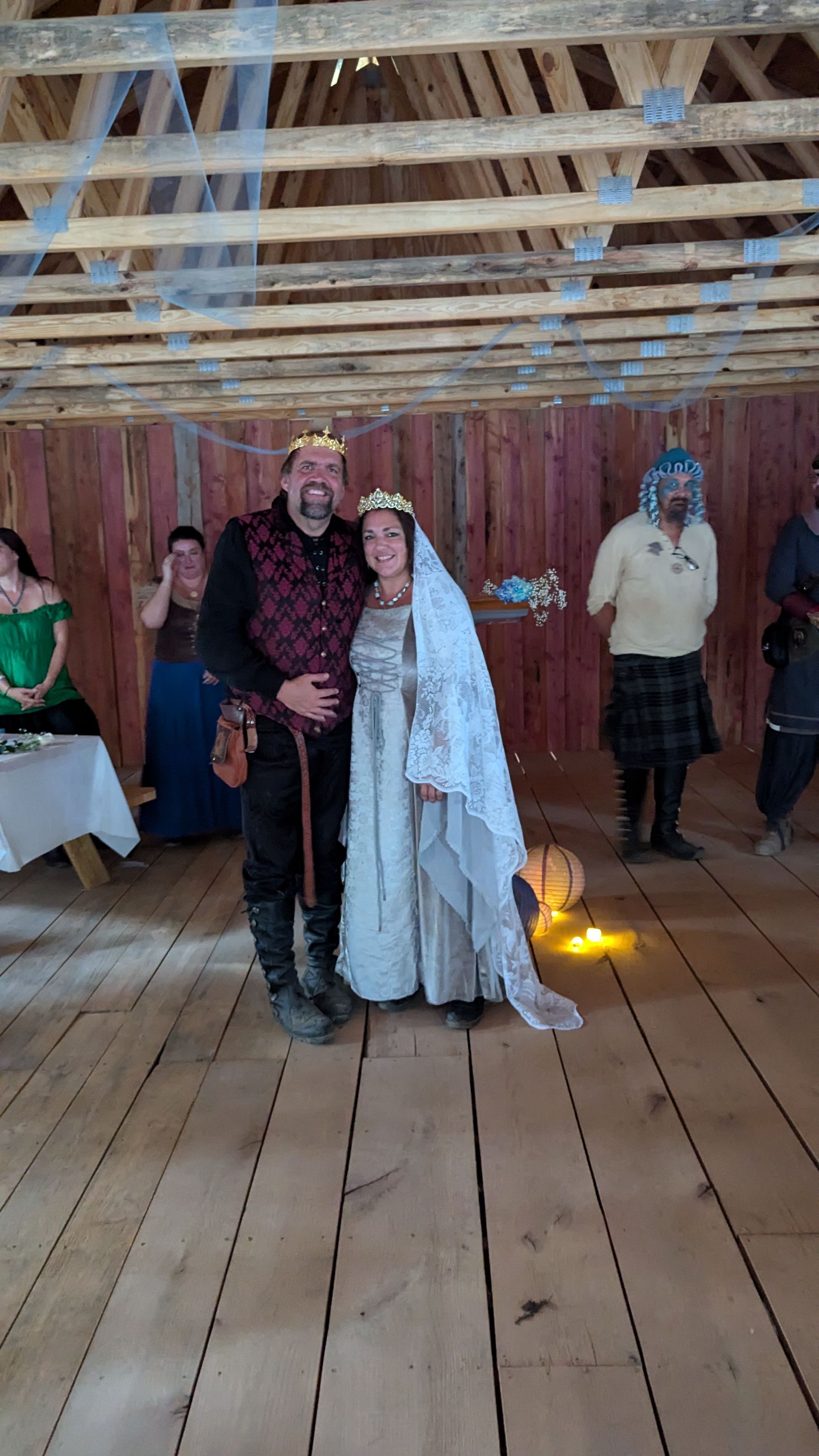 A man and a woman are standing next to each other on a wooden floor getting married at the AR Renaissance Festival