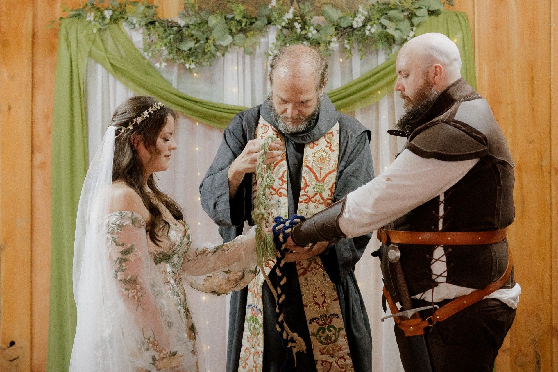 A man and a woman are standing next to each other on a wooden floor getting married at the AR Renaissance Festival
