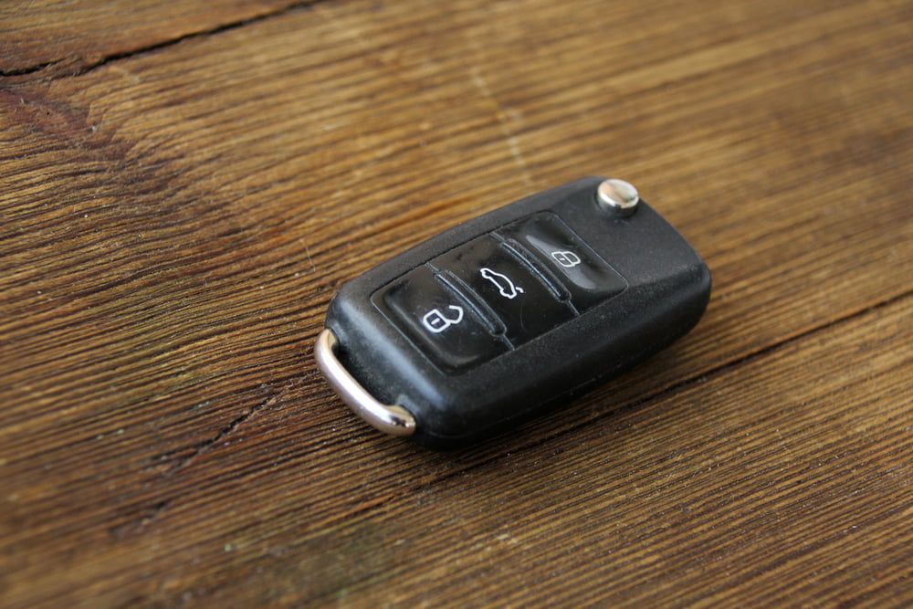 A Car Key is Sitting on a Wooden Table — Battery Assist QLD In Morayfield, QLD