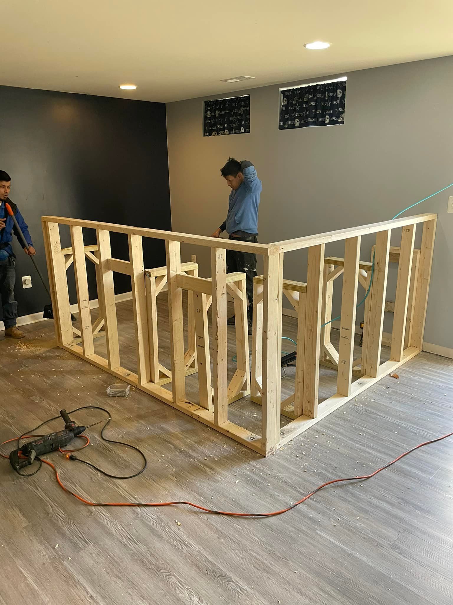 A man is working on a wooden frame in a room.
