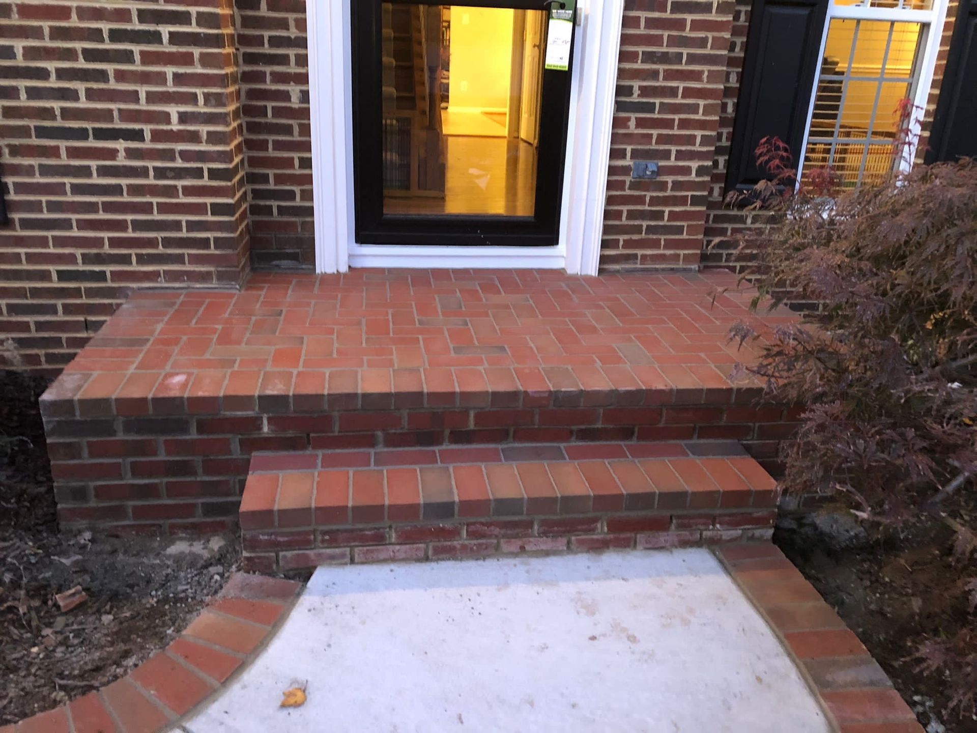 A brick porch with steps leading to the front door of a house