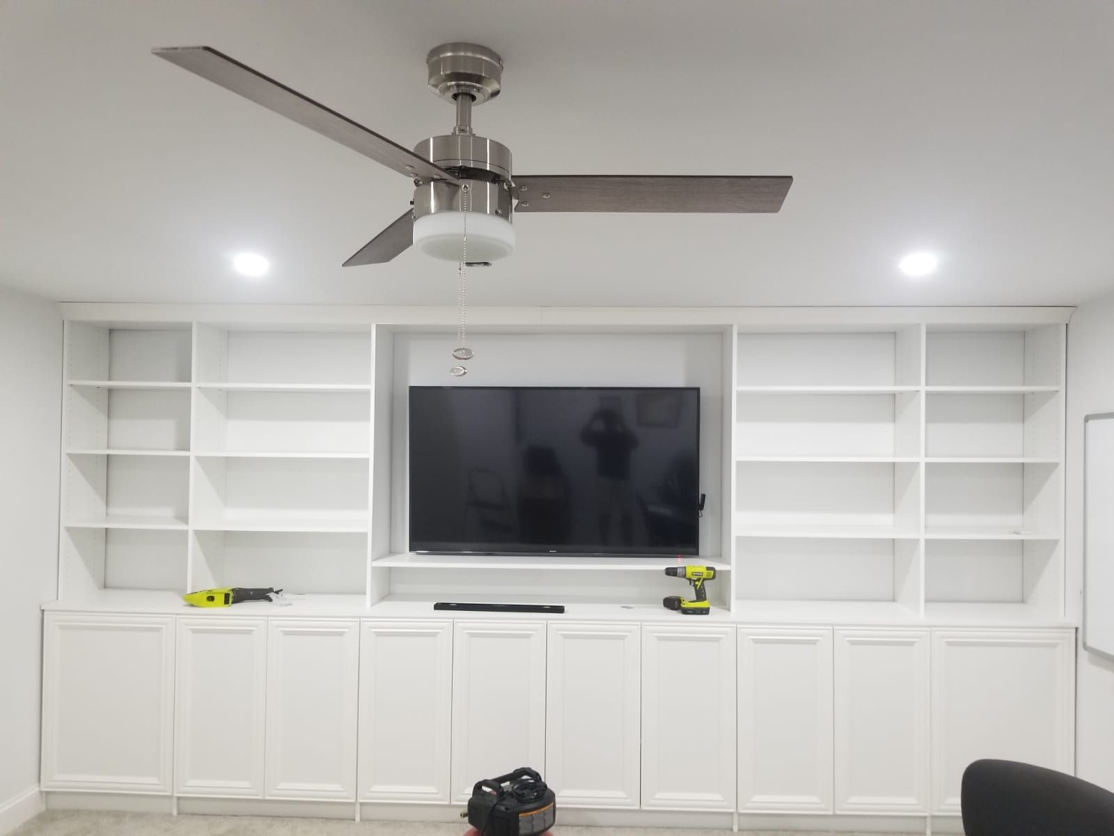 A living room with a ceiling fan and a flat screen tv.