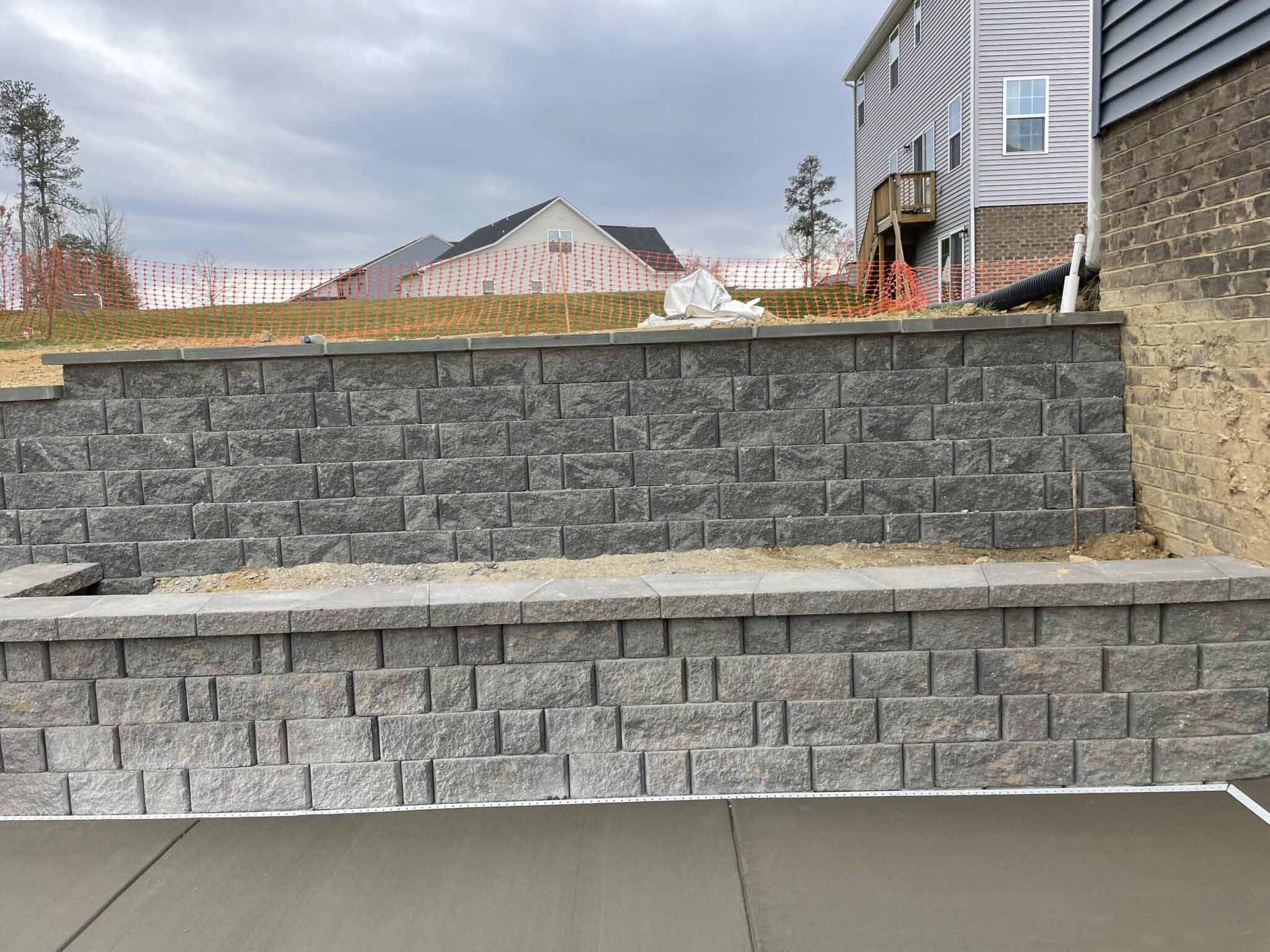 A brick wall is being built in front of a house.