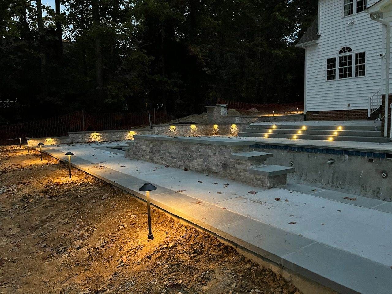 A swimming pool is being built in the backyard of a house.