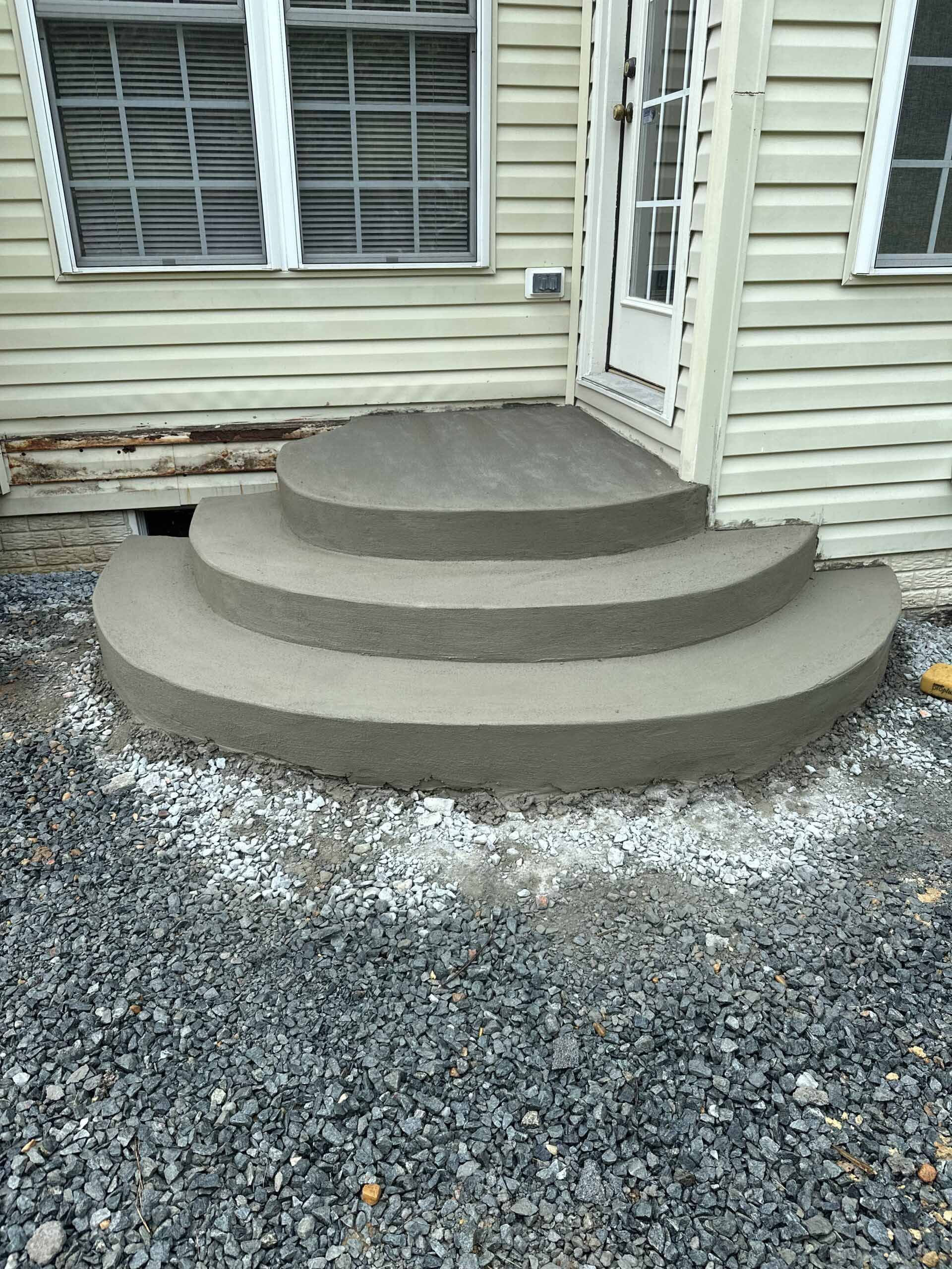 A concrete staircase is being built in front of a house.
