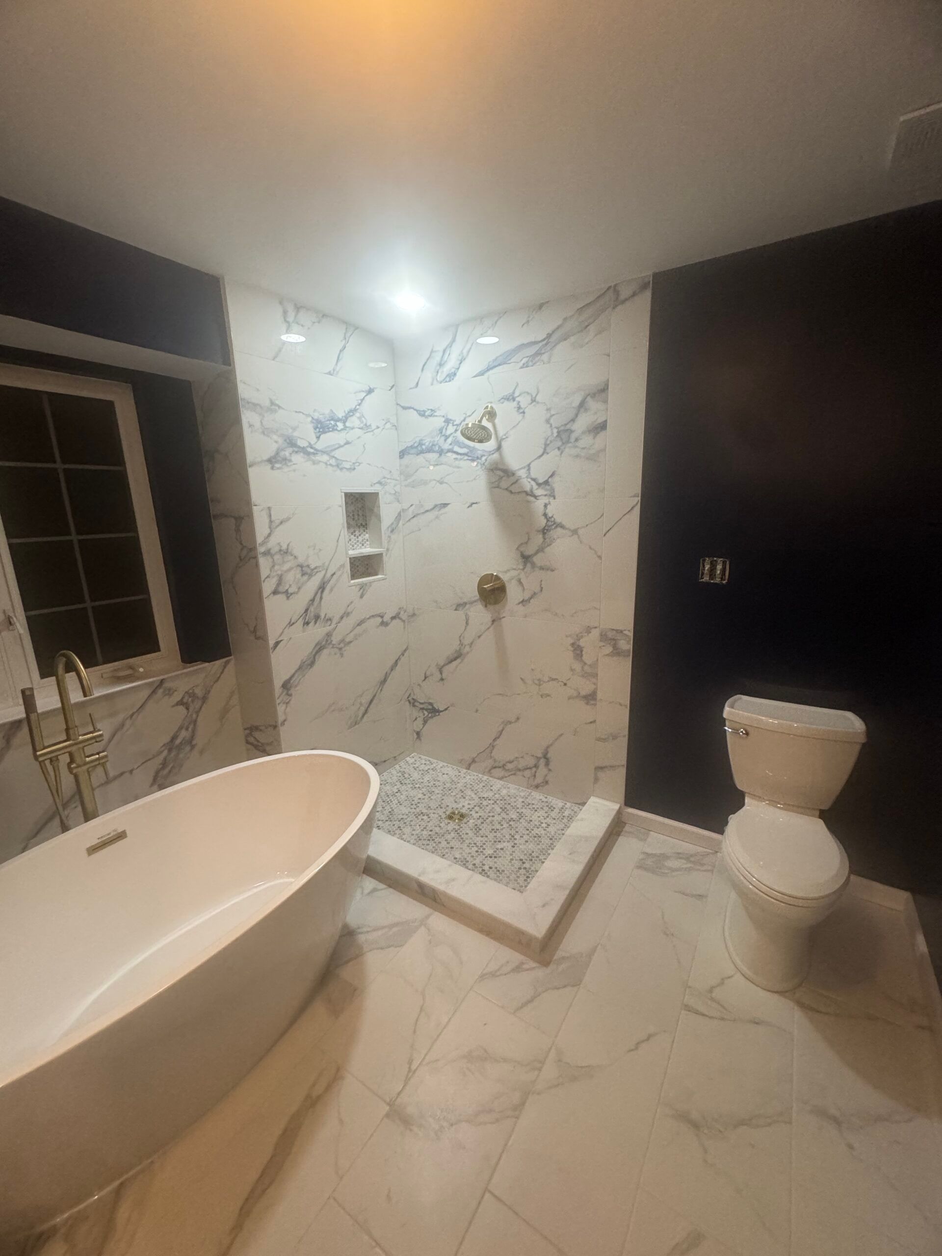 A bathroom with a tub , toilet and shower.