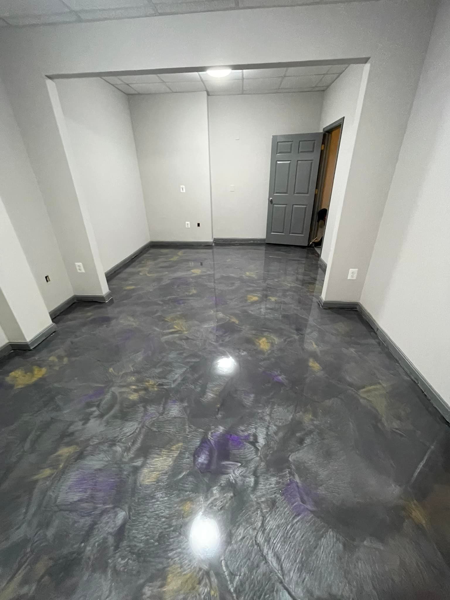 A room with a metallic floor and a door.