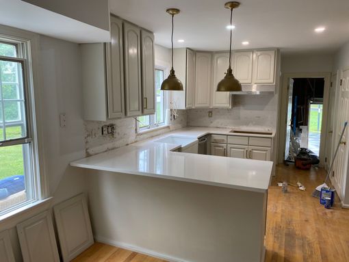 A kitchen with granite counter tops and black cabinets